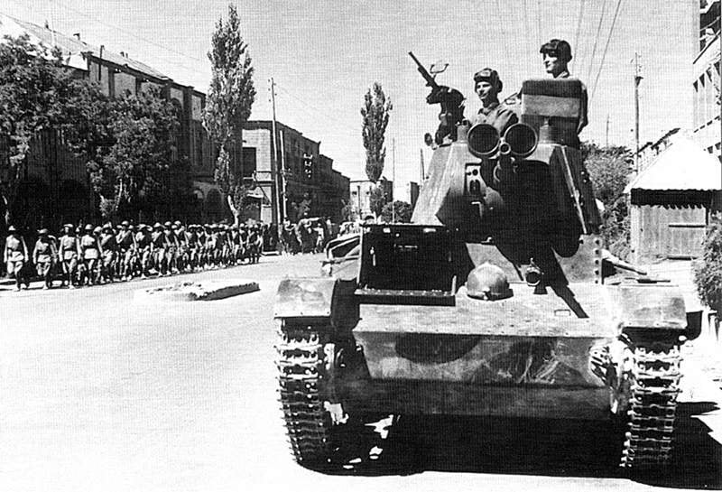 Soviet tankmen of the 6th Armoured Division drive through the streets of Tabriz on their T-26 battle tank.
